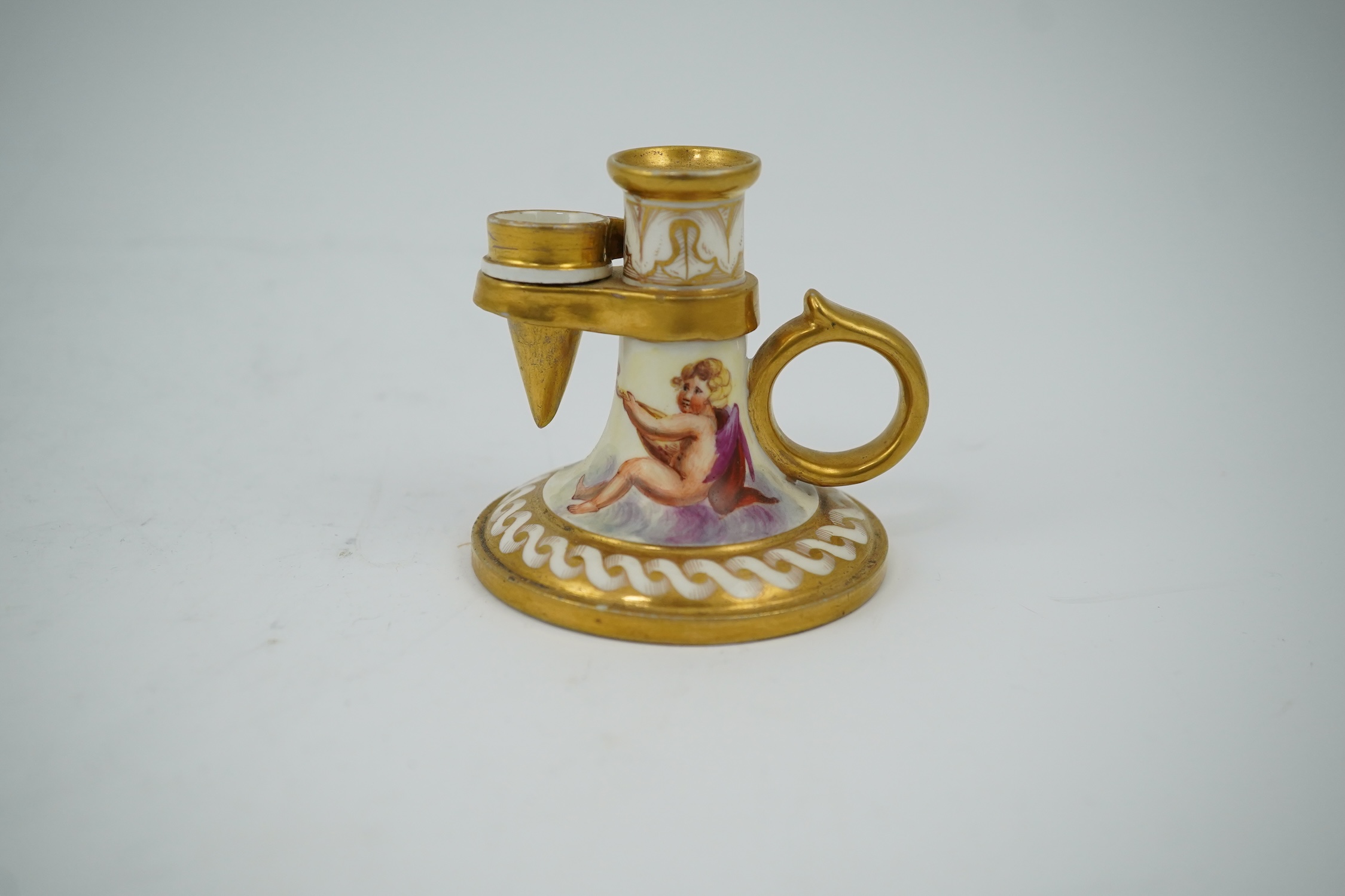 An early 19th century English or French porcelain chamberstick with extinguisher, 7cm high. Condition - extinguisher cracked, chamberstick good